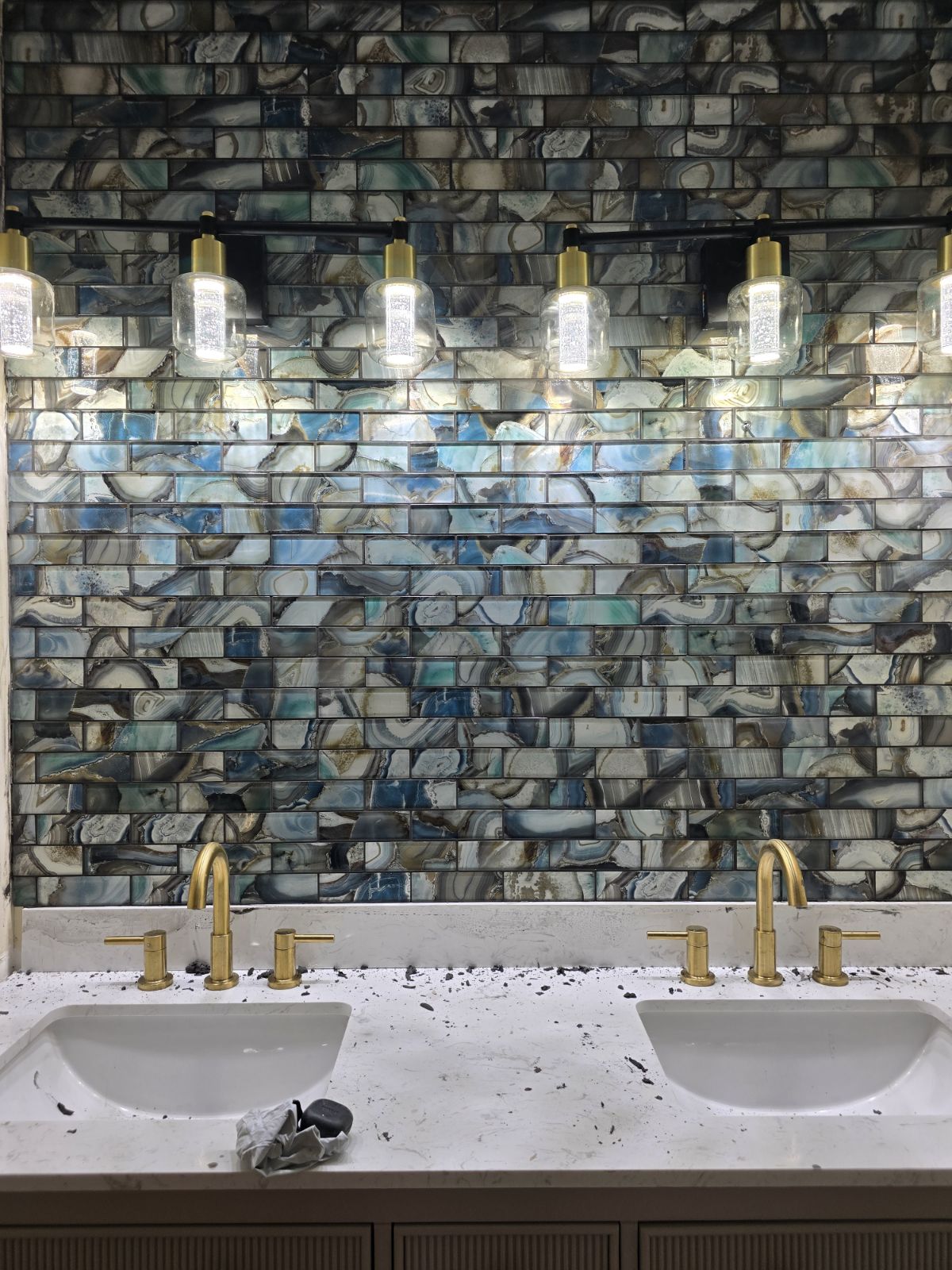 Bathroom vanity with unique blue and green tile backsplash