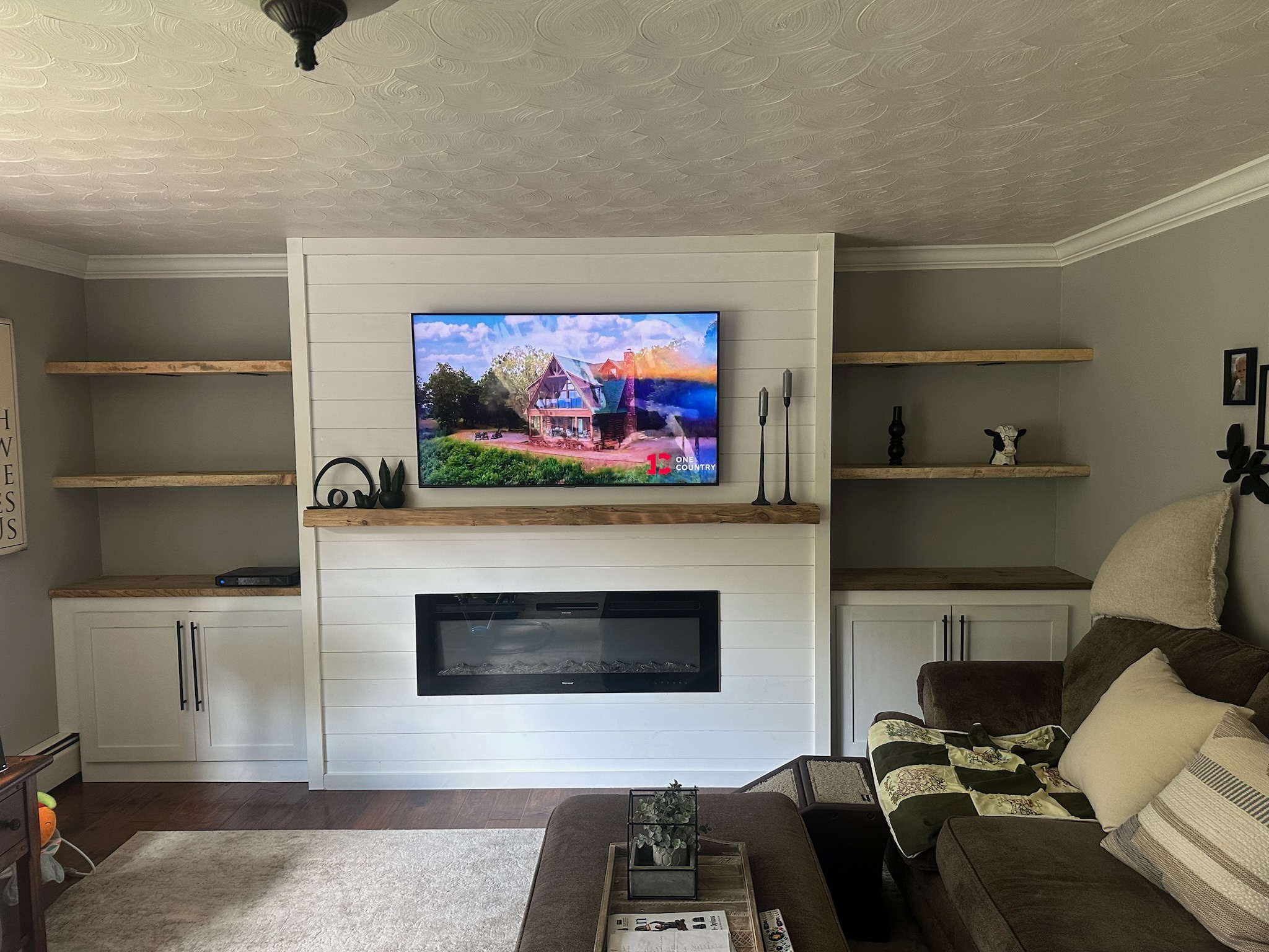 Completed living room feature wall with fireplace and built-in shelves